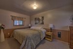 Master bedroom has a king bed with a window viewing the beautiful woods nearby.